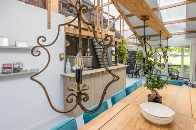 a dining room with a table and blue chairs at Het Kamphuis, landelijk slapen in Heerhugowaard
