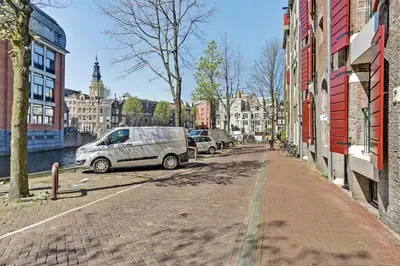 a city street with cars parked next to buildings at City-centre, Canal-house, luxurious , stylish bedroom, ensuite bathroom in Amsterdam