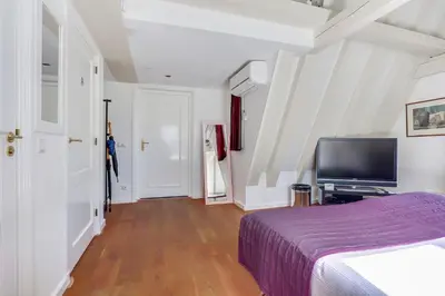 a bedroom with a bed and a flat screen tv at City-centre, Canal-house, luxurious , stylish bedroom, ensuite bathroom in Amsterdam