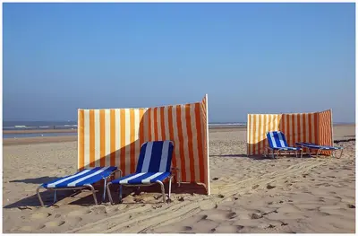 three chairs sitting in the sand on the beach at Hotel De Koningshof in Noordwijk aan Zee