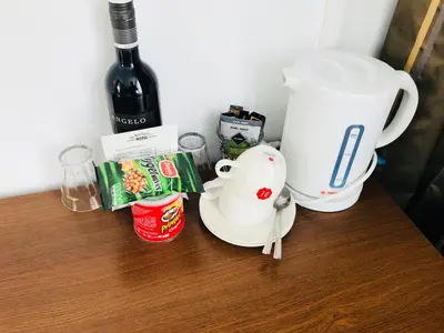 a table with a coffee maker and a bottle of wine at Hotel De Koningshof in Noordwijk aan Zee
