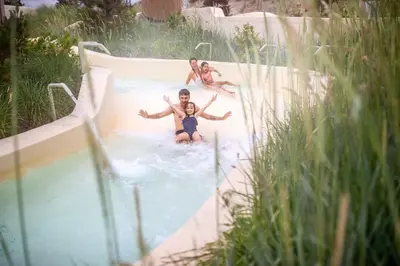 a group of people riding a slide in a pool at Beachhotel Zandvoort by Center Parcs in Zandvoort