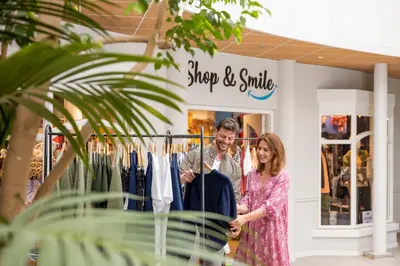 a man and a woman standing in front of a clothing store at Beachhotel Zandvoort by Center Parcs in Zandvoort