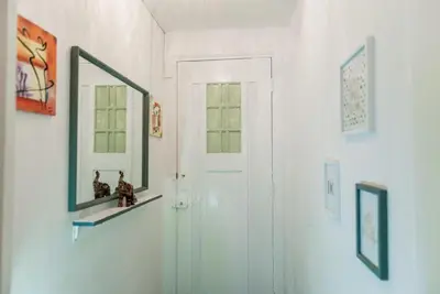 a hallway with a mirror and a white door at Nice 2 double Bed in sunny House in Amsterdam west in Amsterdam