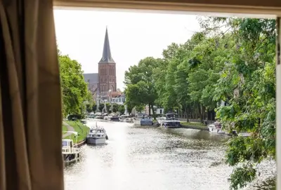 a view from a window of a river with boats at Historical house on river Vecht in Maarssen