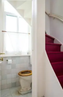 a bathroom with a toilet and some stairs at Historical house on river Vecht in Maarssen