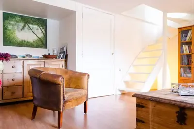 a leather chair in a room with a staircase at Historical house on river Vecht in Maarssen