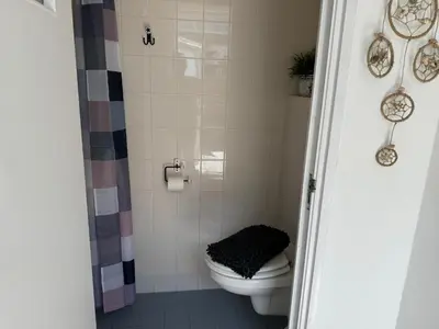 a bathroom with a toilet and a shower at Strandduin - Vakantiewoning aan de Kust - 52 in Egmond aan Zee