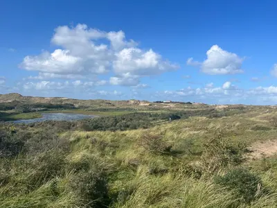 a view of a grassy hill with a river at Strandduin - Vakantiewoning aan de Kust - 52 in Egmond aan Zee