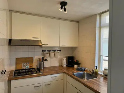 a kitchen with white cabinets and a sink at Strandduin - Vakantiewoning aan de Kust - 52 in Egmond aan Zee
