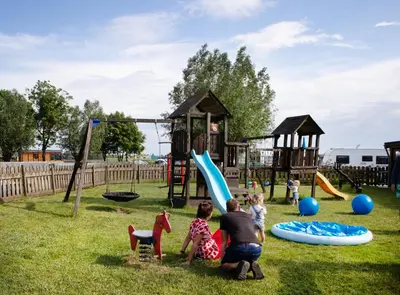 a man and two children playing in a playground at Camping de Speld in Nieuwkoop