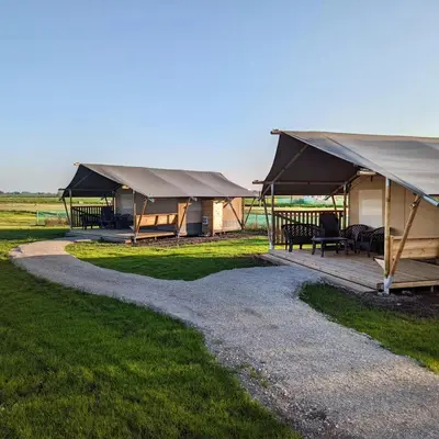 a couple of tents in a grass field at Camping de Speld in Nieuwkoop
