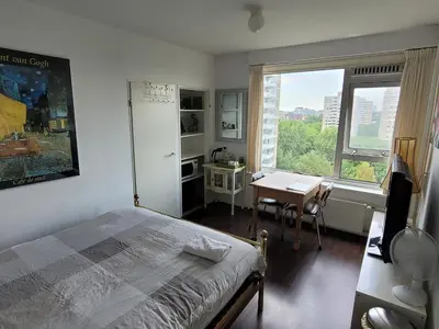 a bedroom with a bed and a desk and a window at Sky Home Room 1 in Amsterdam