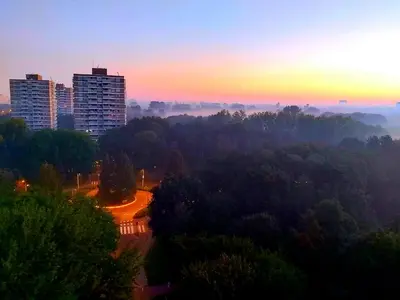 a view of a city at sunset with trees and buildings at Sky Home Room 1 in Amsterdam