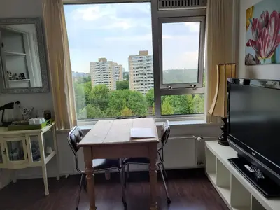 a dining room with a table and two windows at Sky Home Room 1 in Amsterdam