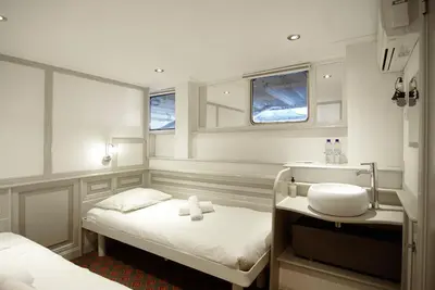 a small room with two beds and a sink at Kapitein Anna in Amsterdam