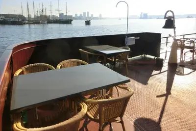 a table and chairs on the deck of a boat at Kapitein Anna in Amsterdam