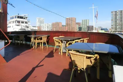 a balcony with tables and chairs on a ship at Kapitein Anna in Amsterdam