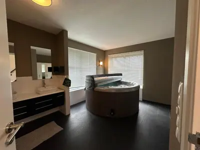 a bathroom with a large tub in the middle of the room at Groot vakantiehuis nabij Amsterdam inclusief jacuzzi in Zeewolde
