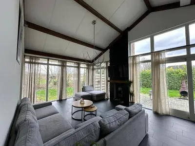 a living room with a couch and a table at Groot vakantiehuis nabij Amsterdam inclusief jacuzzi in Zeewolde