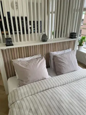 a bed with two pillows on it with at Veldhorst Apartments in Leiden