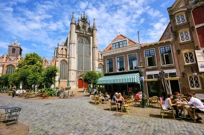 a group of people sitting at tables in front of a church at Veldhorst Apartments in Leiden