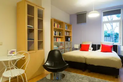 a bedroom with a bed and a desk and a chair at B&B Chez Cho in Utrecht