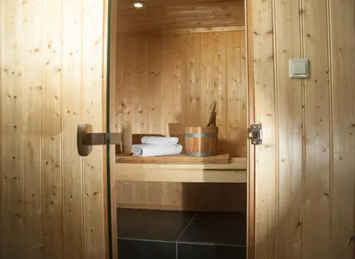 a sauna with wooden walls and a shelf with towels at B&B Chez Cho in Utrecht