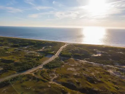 an aerial view of the ocean with the sun in the sky at Chalet in Noordwijk near the Beach in Noordwijk aan Zee