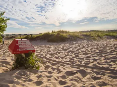 a sign in the sand on a beach at Chalet in Noordwijk near the Beach in Noordwijk aan Zee