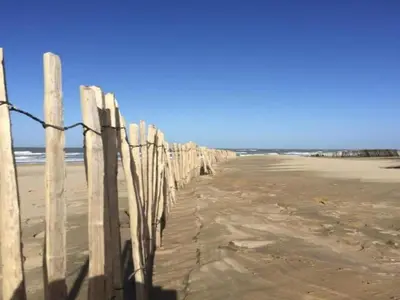 a fence on the beach near the ocean at Chalet in Noordwijk near the Beach in Noordwijk aan Zee