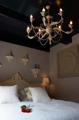 a bedroom with a chandelier and a white bed at Suitehotel Posthoorn in Monnickendam