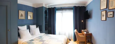 a bedroom with a bed and a desk and a window at Suitehotel Posthoorn in Monnickendam