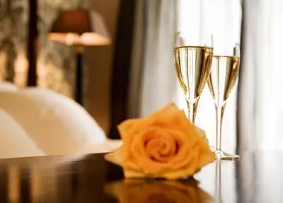 two glasses of champagne and a rose on a table at Suitehotel Posthoorn in Monnickendam