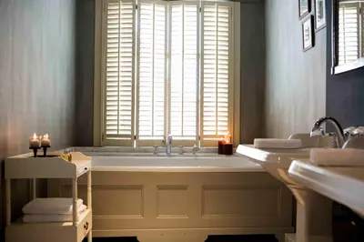a bathroom with a tub and two sinks and a window at Suitehotel Posthoorn in Monnickendam
