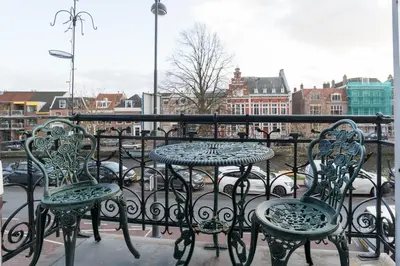 two chairs and a table on a balcony at Canal House Haarlem in Haarlem