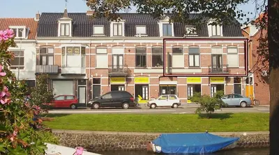 a large building with cars parked in front of it at Canal House Haarlem in Haarlem