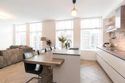 a kitchen and living room with a table and a couch at Canal House Haarlem in Haarlem
