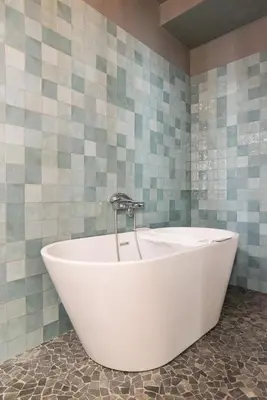 a bath tub with a faucet in a bathroom at Canal House Haarlem in Haarlem