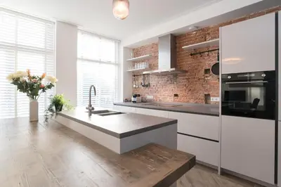 a kitchen with a counter and a brick wall at Canal House Haarlem in Haarlem