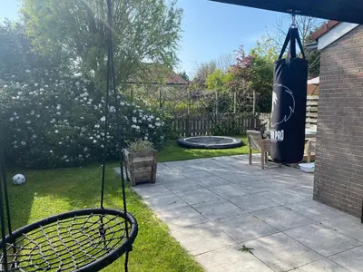 a backyard with a tennis racket and a swing at Huis Egmond in Egmond aan den Hoef