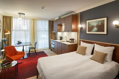 a hotel room with a bed and a kitchen at Nova Apartments Amsterdam in Amsterdam