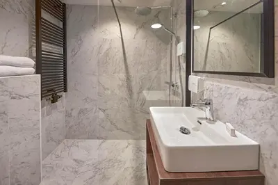 a white bathroom with a sink and a shower at Nova Apartments Amsterdam in Amsterdam