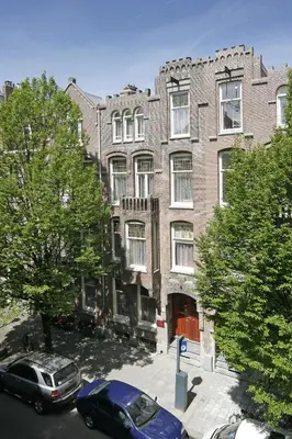 a large brick building with cars parked in front of it at Nova Apartments Amsterdam in Amsterdam