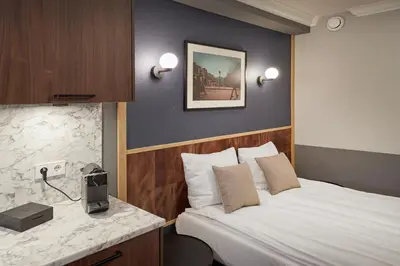 a hotel room with a bed and a desk at Nova Apartments Amsterdam in Amsterdam