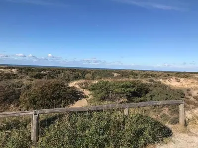 a view of the ocean from the top of a wooden fence at Holiday Home in Noordwijk near the Beach in Noordwijk aan Zee