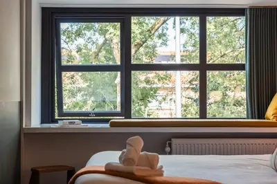 a bedroom with two large windows and a bed at Badhuis Hotel in Utrecht
