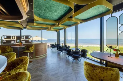 a restaurant with a view of the ocean at Strandhotel Het Hoge Duin in Wijk aan Zee