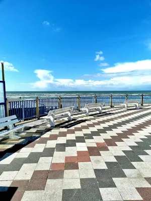 a row of benches on a pier overlooking the ocean at De Schelp 58 in Zandvoort