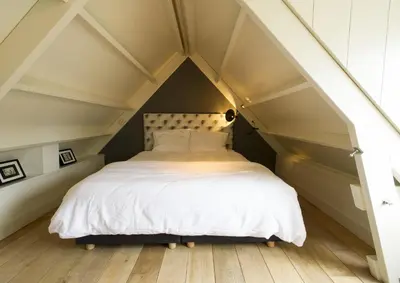 a bedroom with a bed in an attic at Waterland Vakantiehuis in Monnickendam